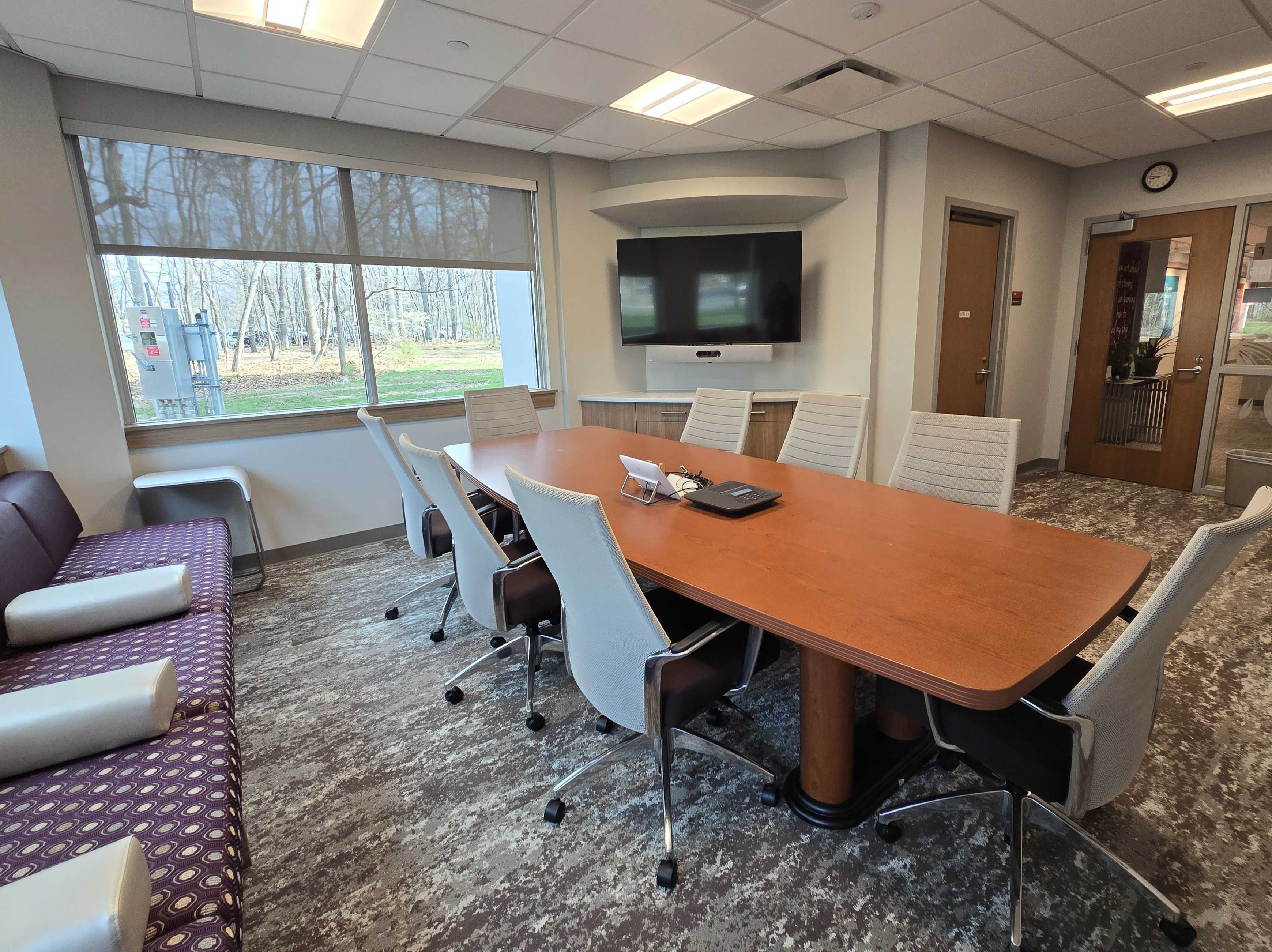 Conference room with rectangular table and 8 chairs in the middle