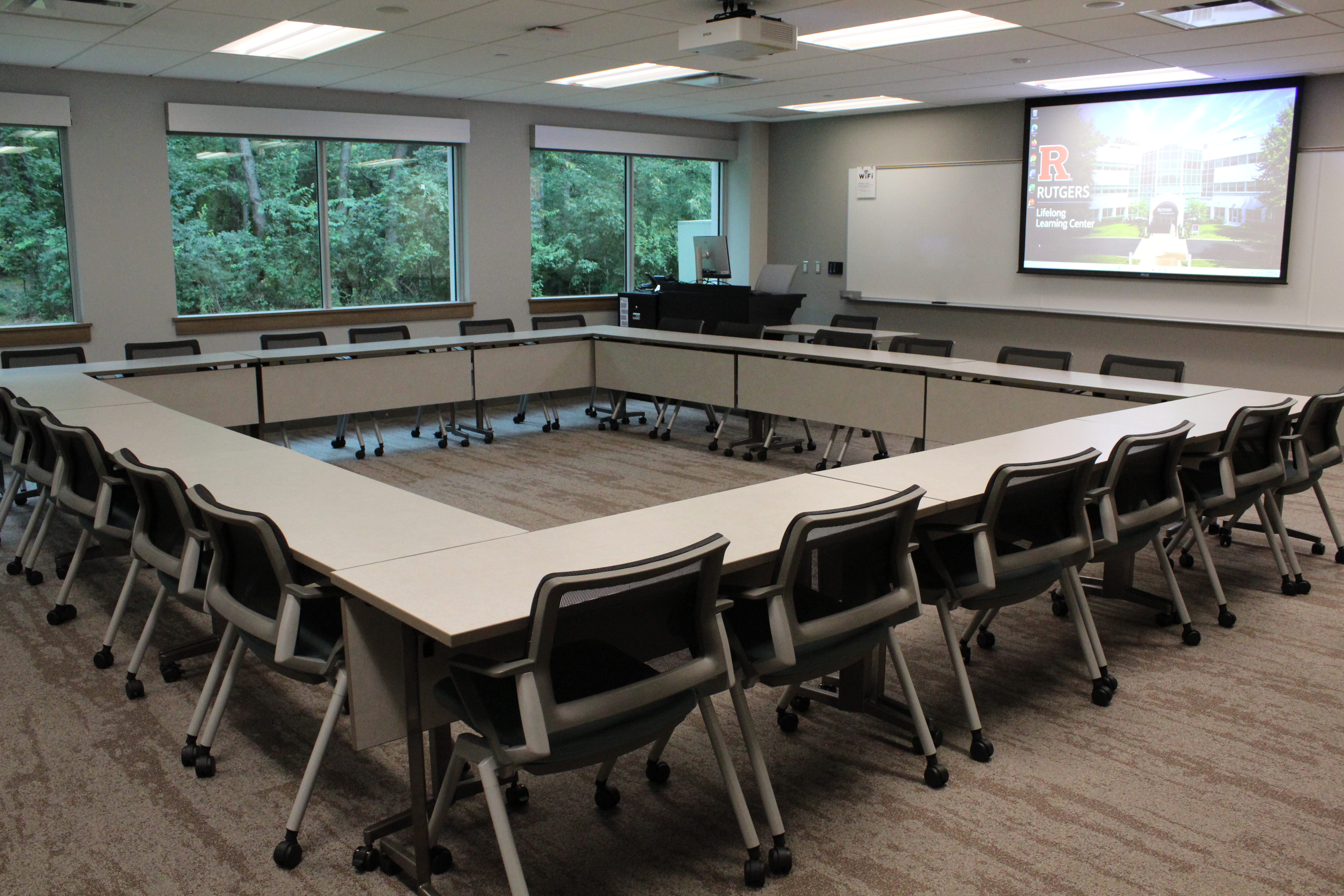 Classroom photo in a hollow-square room layout and screen in the front